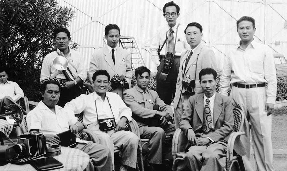 新華社記者錢嗣杰（站立者右二）在采訪會議開幕式后和外國記者在會場外休息。